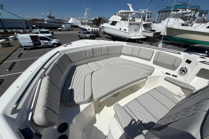 Slide: The Image of Luxurious seating on 2026 Pursuit S 358 Sport boat, docked with other vessels nearby. - 128