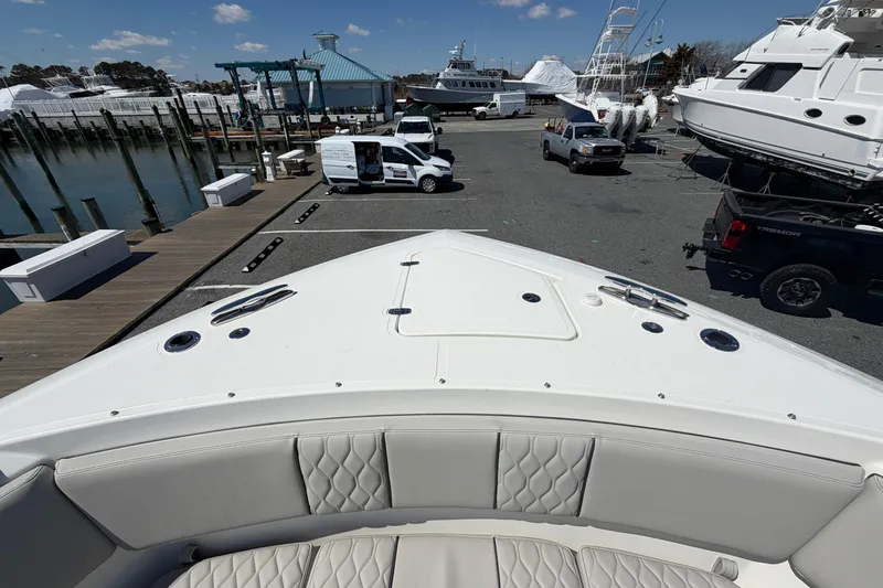 Slide: The Image of Bow view of 2026 Pursuit S 358 Sport boat at marina with parked vehicles. - 130