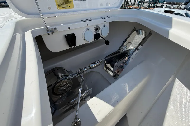 Slide: The Image of Anchor compartment of 2026 Pursuit S 358 Sport boat, featuring winch and chain mechanism. - 132