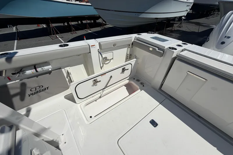 Slide: The Image of 2026 Pursuit S 358 Sport boat deck with storage compartments and fishing rod holders. - 26