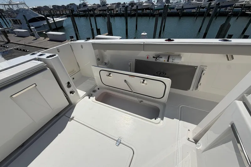 Slide: The Image of 2026 Pursuit S 358 Sport boat deck with storage compartments at marina. - 35