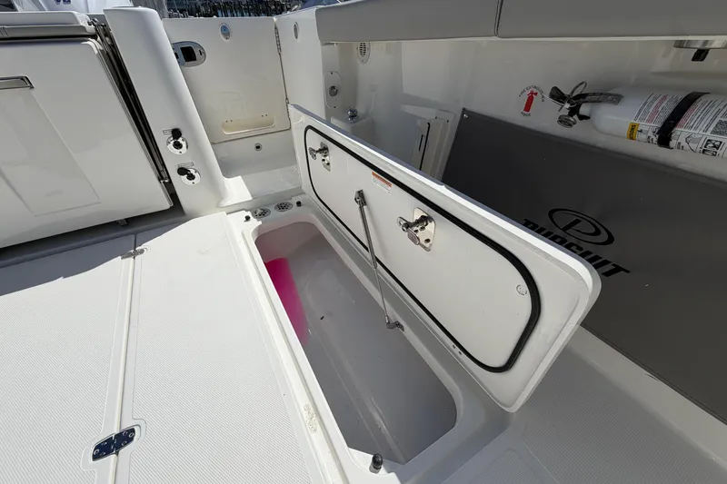 Slide: The Image of 2026 Pursuit S 358 Sport boat interior with open storage compartment and safety equipment. - 36