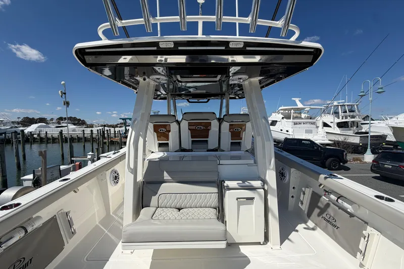 Slide: The Image of 2026 Pursuit S 358 Sport boat interior at marina, showcasing seating and helm. - 38
