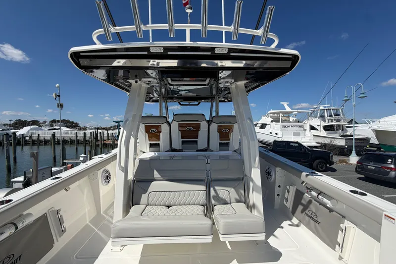 Slide: The Image of 2026 Pursuit S 358 Sport boat interior with seating, docked at marina under clear blue sky. - 39