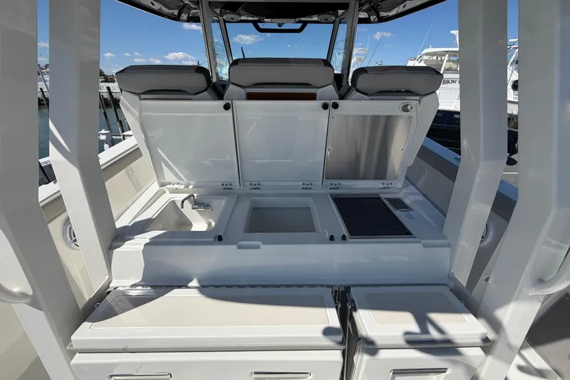 Slide: The Image of 2026 Pursuit S 358 Sport boat interior with open storage compartments and sink. - 43