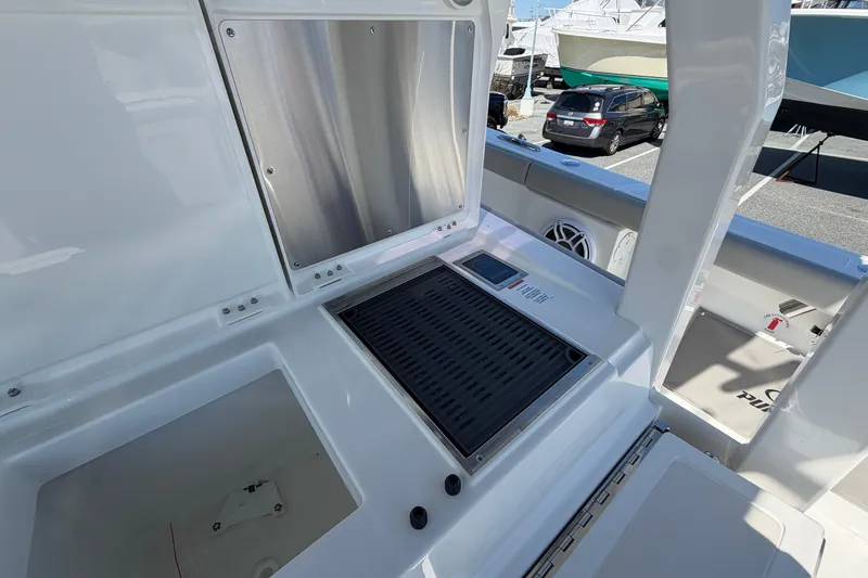 Slide: The Image of 2026 Pursuit S 358 Sport boat interior with grill and storage compartments. - 46