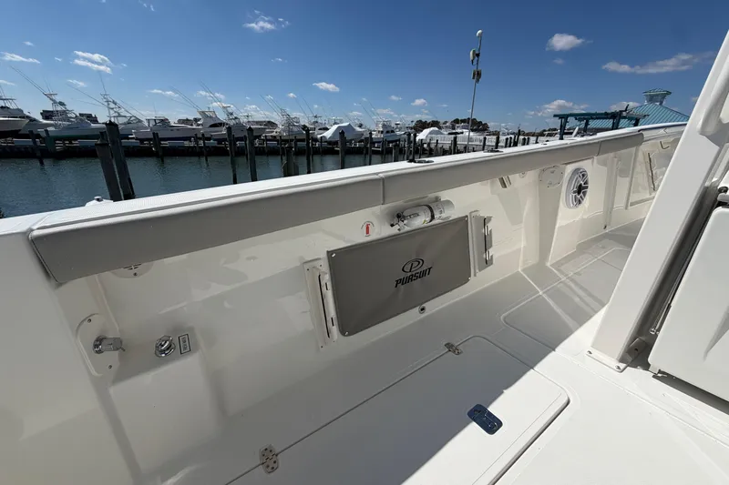 Slide: The Image of 2026 Pursuit S 358 Sport boat deck with marina view under clear blue sky. - 53