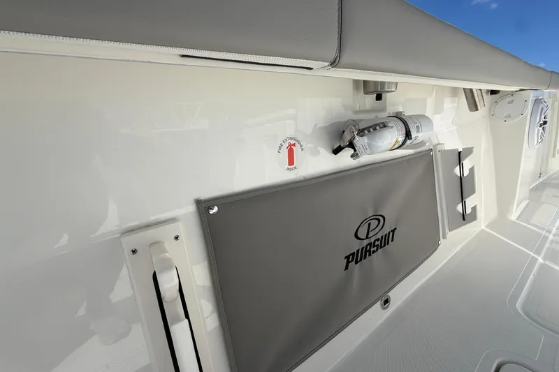 Slide: The Image of 2026 Pursuit S 358 Sport boat interior with fire extinguisher and branded storage compartment. - 54