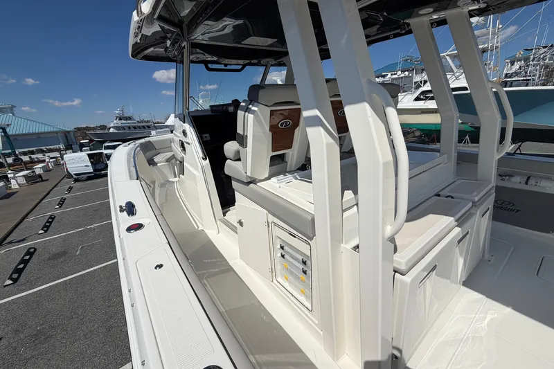 Slide: The Image of 2026 Pursuit S 358 Sport boat interior with seating and control panel at a marina. - 56