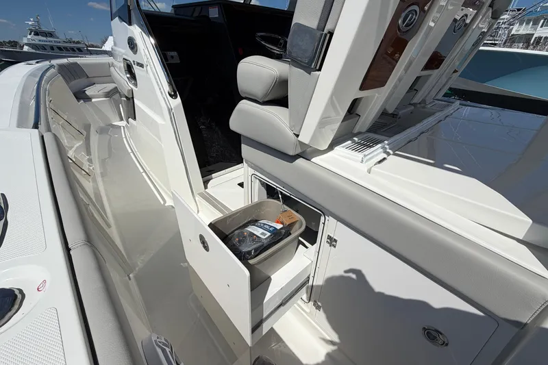 Slide: The Image of 2026 Pursuit S 358 Sport boat interior with open storage compartment and seating. - 58