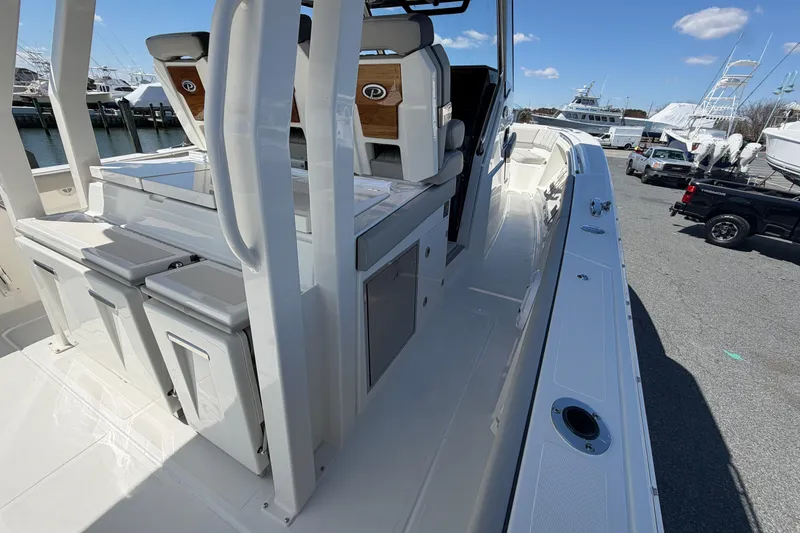 Slide: The Image of 2026 Pursuit S 358 Sport boat interior with seating and storage, docked at marina. - 61