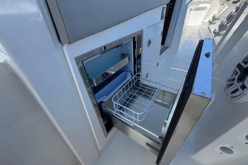 Slide: The Image of Open storage compartment on 2026 Pursuit S 358 Sport boat, featuring a wire basket and sleek design. - 63