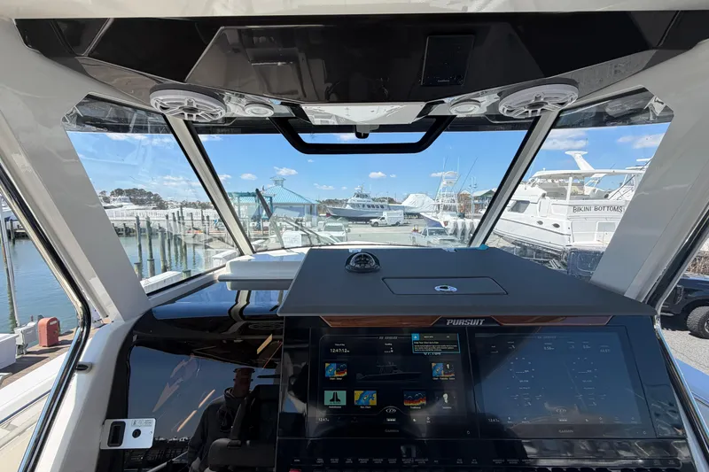 Slide: The Image of Interior view of 2026 Pursuit S 358 Sport boat cockpit with marina background. - 78