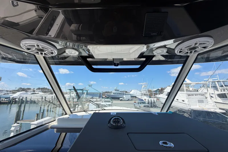 Slide: The Image of Interior view of 2026 Pursuit S 358 Sport boat at marina, showcasing dashboard and speakers. - 79
