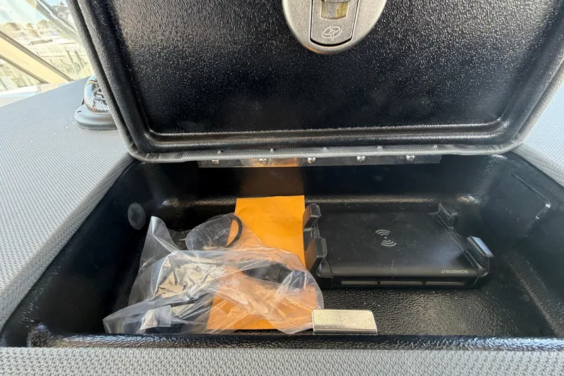 Slide: The Image of Storage compartment in 2026 Pursuit S 358 Sport boat with wireless charging pad and accessories. - 80