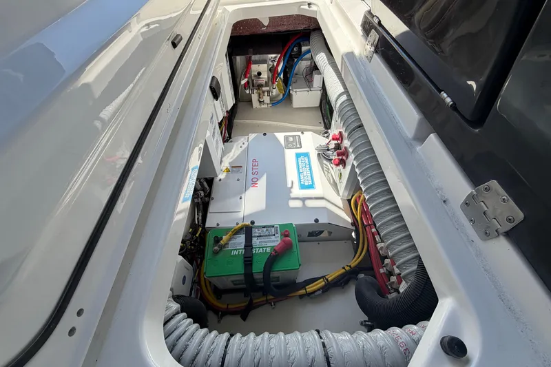 Slide: The Image of Engine compartment of 2026 Pursuit S 358 Sport boat, showcasing battery and wiring. - 83
