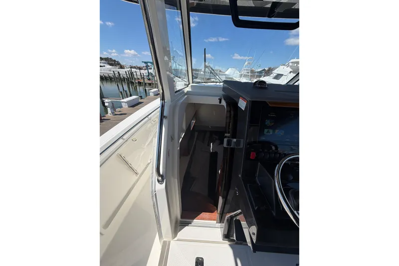 Slide: The Image of 2026 Pursuit S 358 Sport boat interior with helm and cabin entrance. - 88