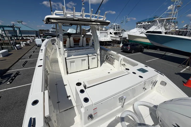 Slide: The Image of 2026 Pursuit S 358 Sport boat docked, showcasing spacious deck and seating area. - 9