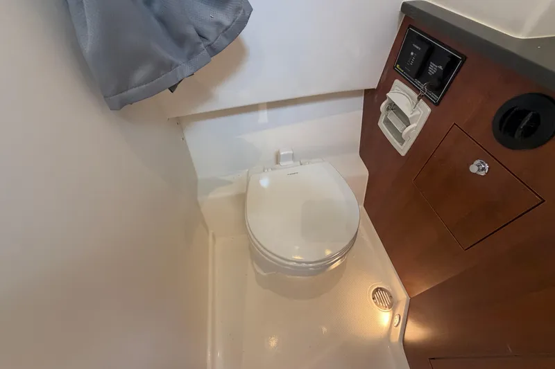 Slide: The Image of 2026 Pursuit S 358 Sport boat bathroom with compact toilet and wooden cabinetry. - 98