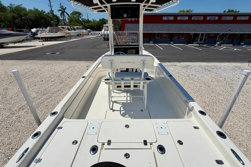 Slide: The Image of 2008 ShearWater 2400Z boat interior with center console and seating, parked outdoors. - 11