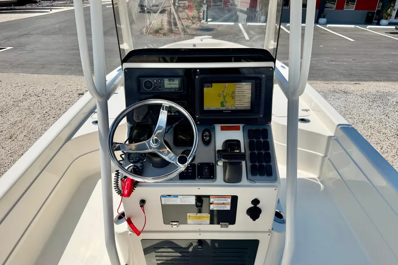 Slide: The Image of Center console of a 2008 ShearWater 2400Z boat with steering wheel and navigation system. - 13