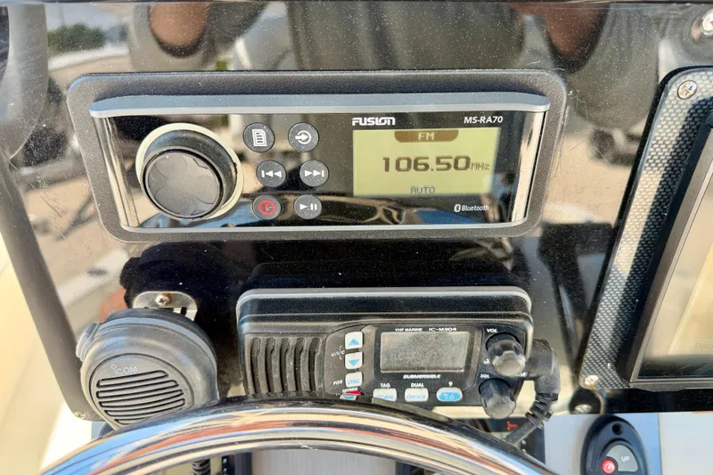 Slide: The Image of Console of a 2008 ShearWater 2400Z boat featuring Fusion MS-RA70 radio and Icom VHF marine radio. - 16