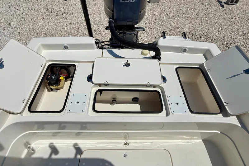 Slide: The Image of 2008 ShearWater 2400Z boat deck with open storage compartments and engine view. - 27