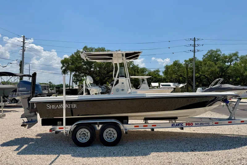 Slide: The Image of 2008 ShearWater 2400Z boat on trailer, parked outdoors under clear blue sky. - 4