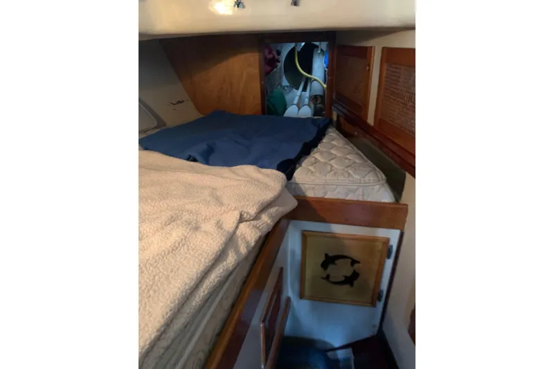 Slide: The Image of Cozy cabin interior of a 1960 Rhodes Bounty sailboat with bedding and wooden accents. - 11