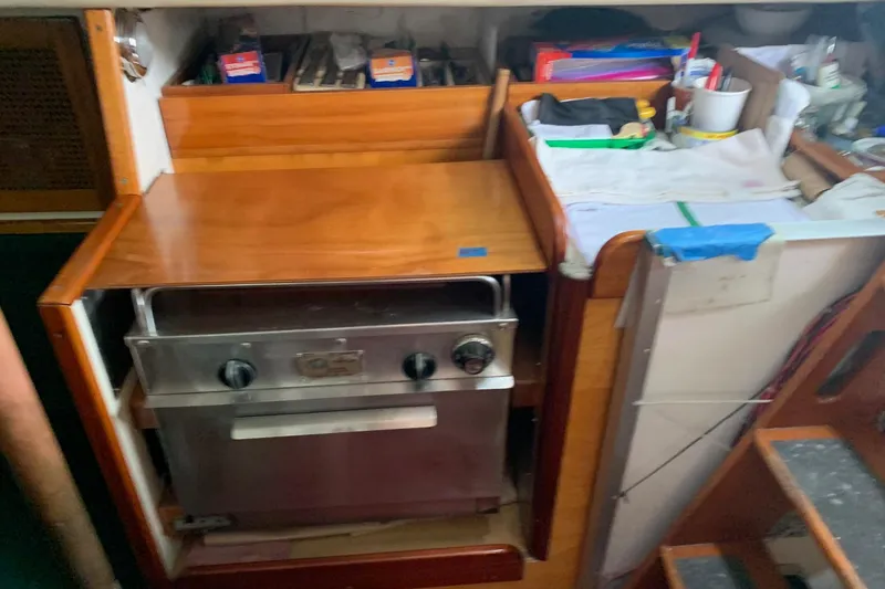 Slide: The Image of 1960 Rhodes Bounty yacht interior with wooden cabinetry and compact stainless steel oven. - 12