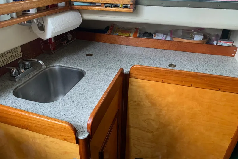 Slide: The Image of 1960 Rhodes Bounty boat kitchen with sink, wooden cabinets, and countertop. - 7
