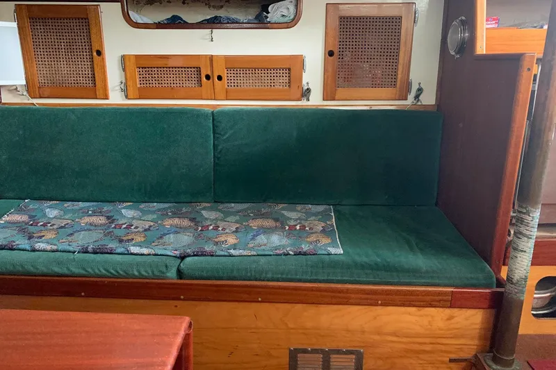 Slide: The Image of Vintage 1960 Rhodes Bounty boat interior with green cushioned seating and wooden cabinets. - 9