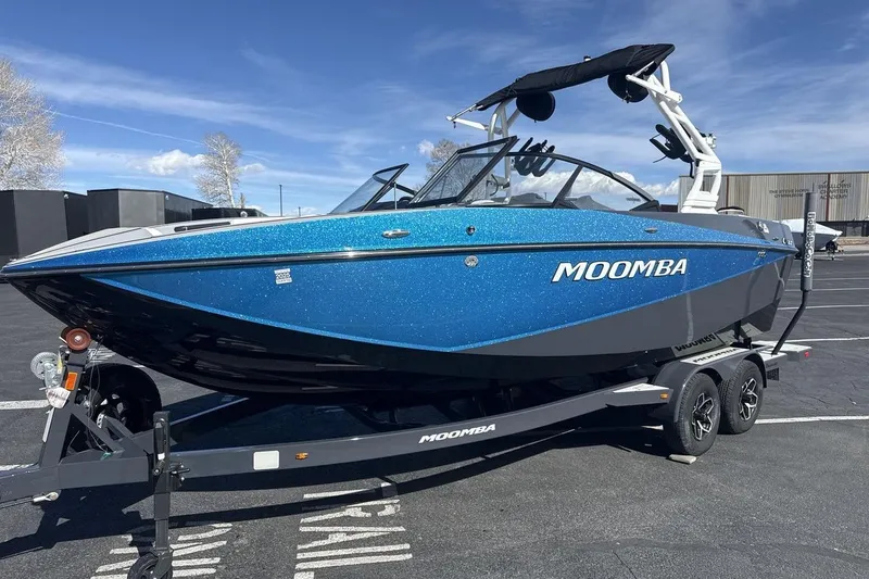 The Image of 2025 Moomba Craz boat in vibrant blue on a trailer, parked outdoors. - 1