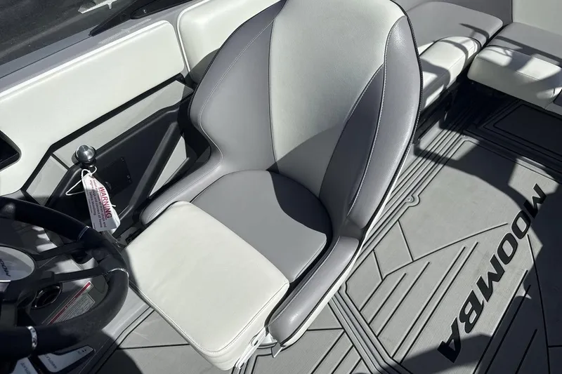 Slide: The Image of 2025 Moomba Craz boat interior with gray and white seating and steering wheel. - 13