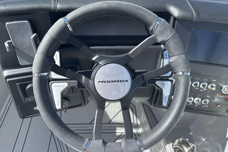 Slide: The Image of Steering wheel of 2025 Moomba Craz boat with control panel and wakeplate switches. - 14