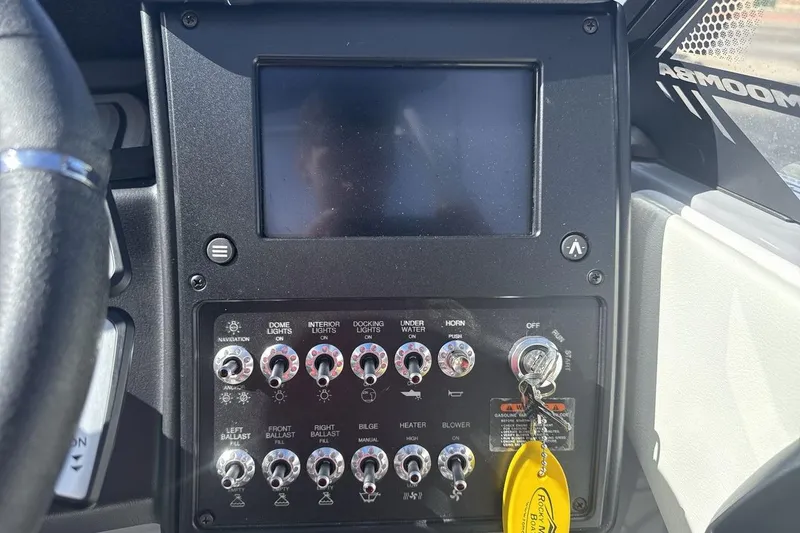 Slide: The Image of Dashboard of a 2025 Moomba Craz boat with control switches and ignition key. - 15