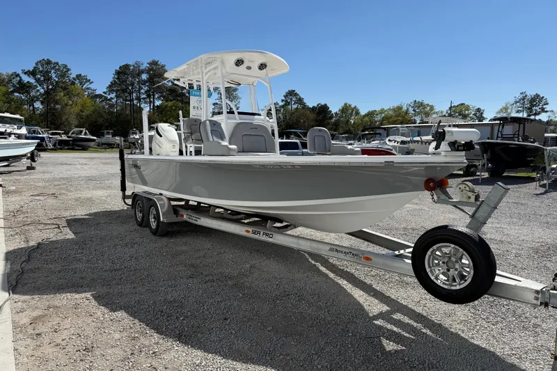 Slide: The Image of 2021 Sea Pro 248 Bay boat on trailer, parked outdoors under clear blue sky. - 12