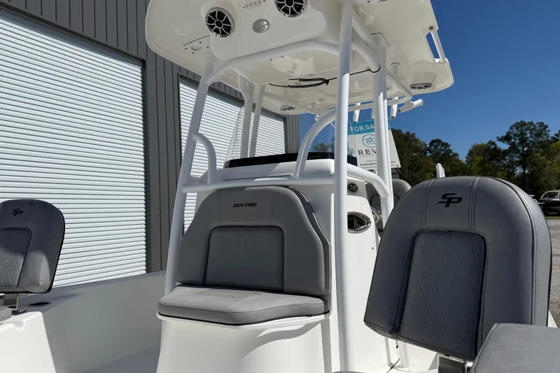 Slide: The Image of 2021 Sea Pro 248 Bay boat interior with gray seating and white console. - 18