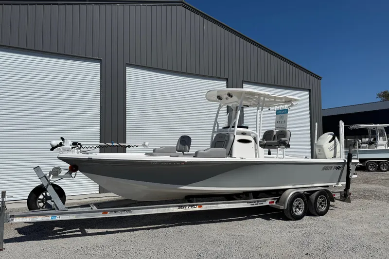 Slide: The Image of 2021 Sea Pro 248 Bay boat on trailer, parked outside a storage facility. - 2