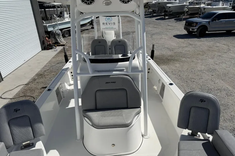 Slide: The Image of 2021 Sea Pro 248 Bay boat interior with gray seating and console, parked outdoors. - 23