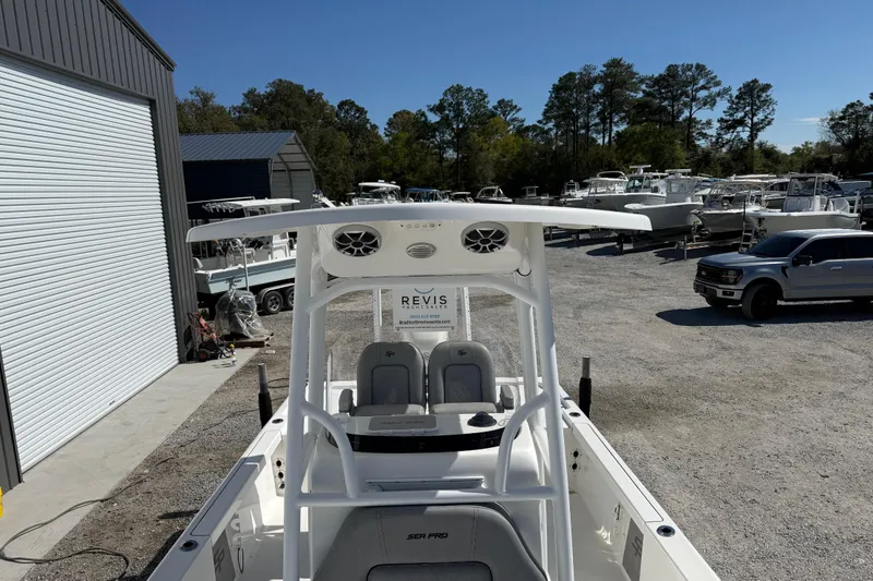 Slide: The Image of 2021 Sea Pro 248 Bay boat in a marina with parked vehicles and boats. - 24