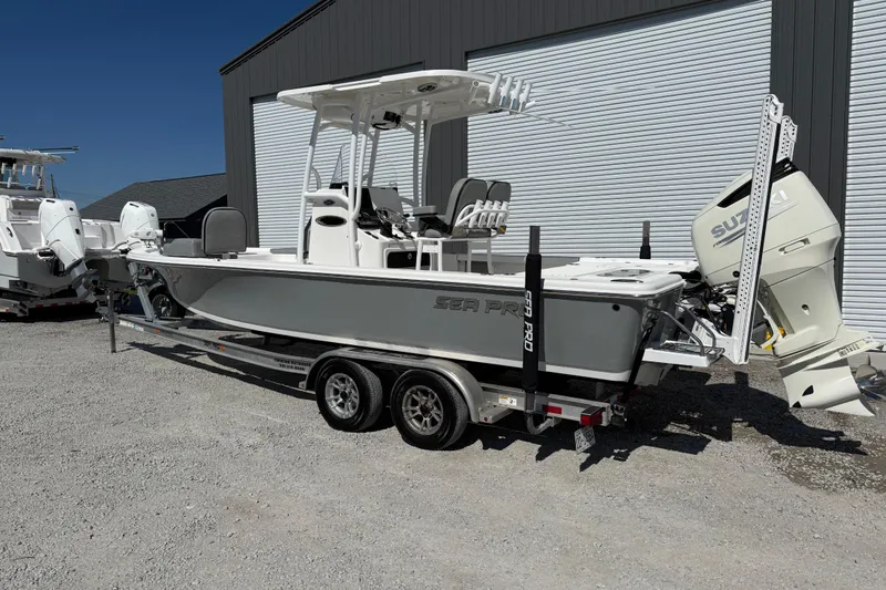Slide: The Image of 2021 Sea Pro 248 Bay boat on trailer, parked outdoors near a building. - 3
