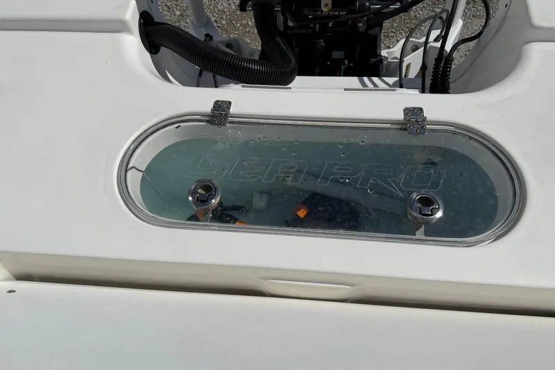Slide: The Image of 2021 Sea Pro 248 Bay boat livewell with clear lid and visible branding. - 30