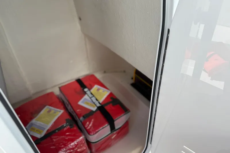 Slide: The Image of Storage compartment in 2021 Sea Pro 248 Bay boat with red life jackets. - 37