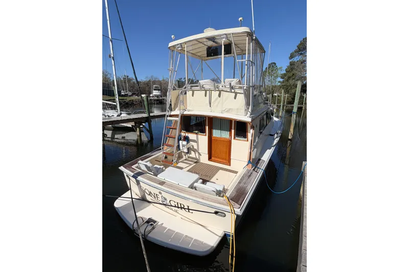 Slide: The Image of 1988 Pacemaker 36 Convertible yacht docked, featuring a spacious deck and upper helm. - 10