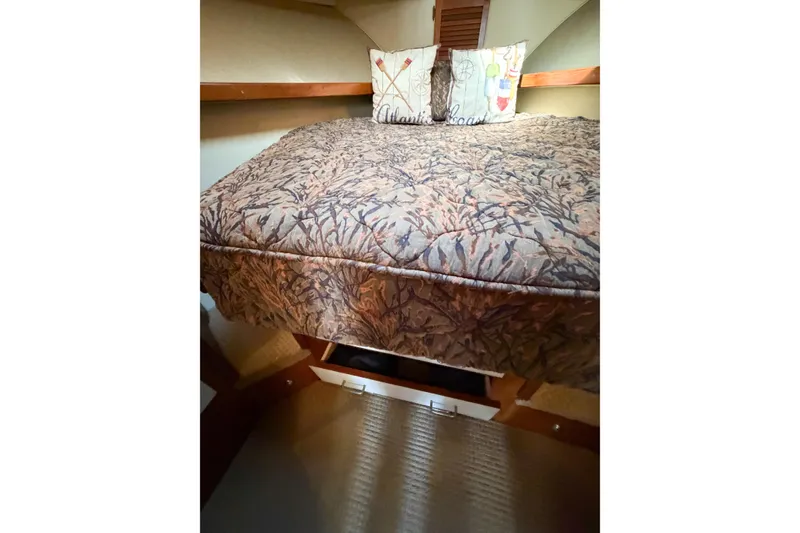 Slide: The Image of Cozy cabin interior of 1988 Pacemaker 36 Convertible with patterned bedding and decorative pillows. - 103