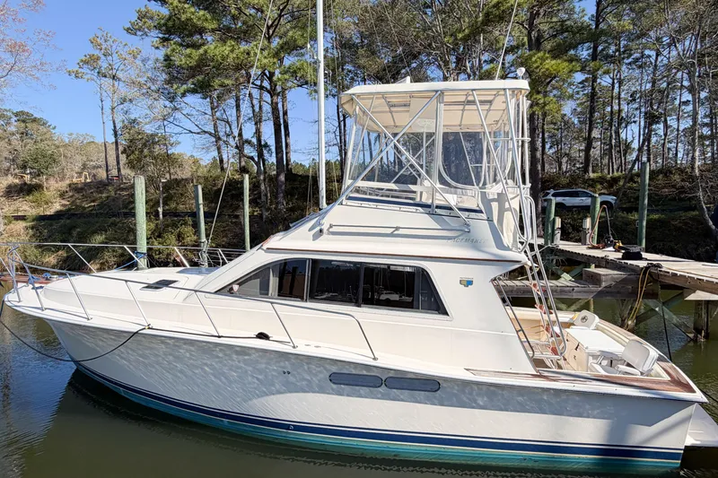 Slide: The Image of 1988 Pacemaker 36 Convertible yacht docked in a serene marina setting. - 12