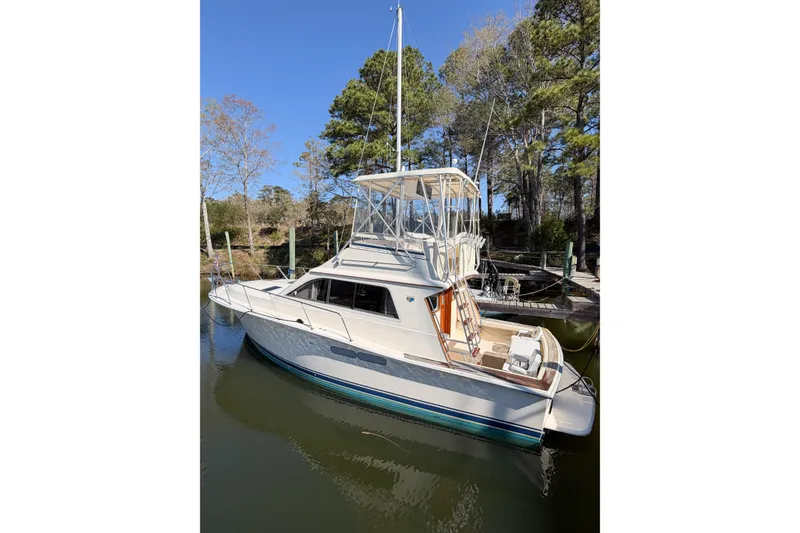 Slide: The Image of 1988 Pacemaker 36 Convertible yacht docked in a serene marina setting. - 14