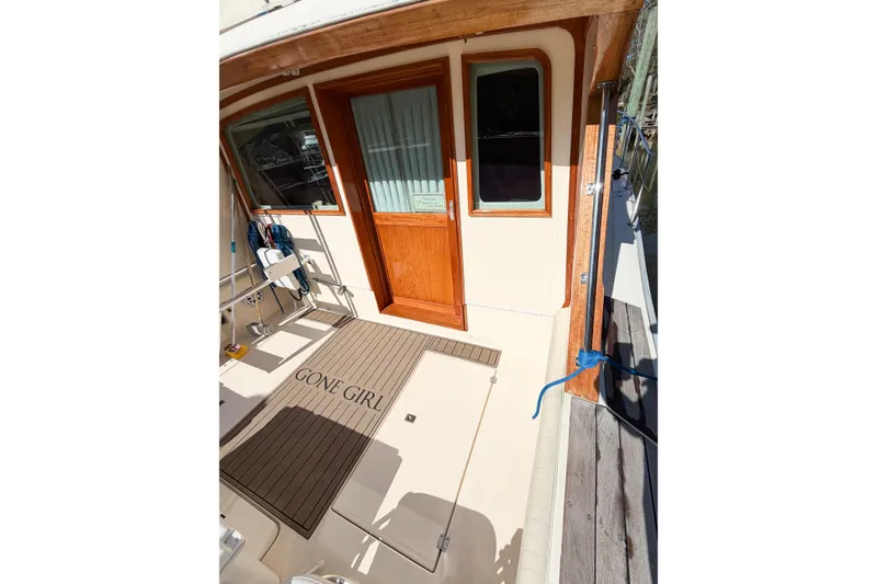 Slide: The Image of 1988 Pacemaker 36 Convertible boat deck with "Gone Girl" mat, wooden door, and window. - 17