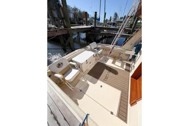 Slide: The Image of 1988 Pacemaker 36 Convertible boat deck with seating and storage at a marina. - 19